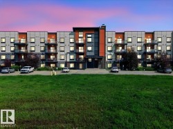 Contemporary building exterior featuring a multi-tone facade with dark grey, light grey, and orange accents - 