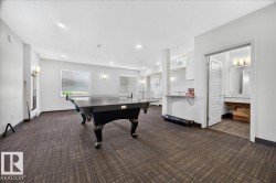 Spacious recreation room featuring patterned carpet, recessed lighting, and dual wall sconces - 