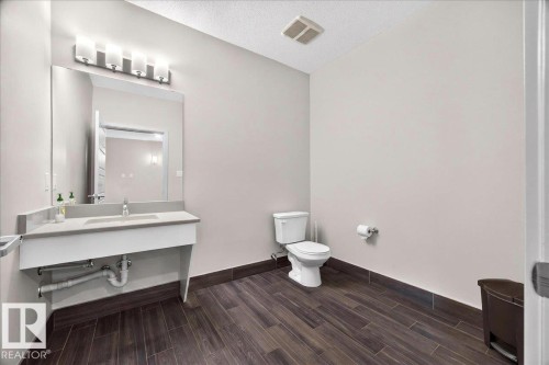 Bathroom featuring wood-look tile flooring and light gray wall paint - 106 320 Ambleside Link Sw, Edmonton, AB - Indoor Photo Showing Bathroom