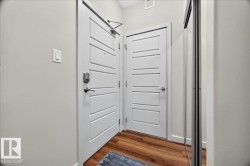 Entryway featuring wood-finish flooring, white paneled doors, and a mirrored closet - 