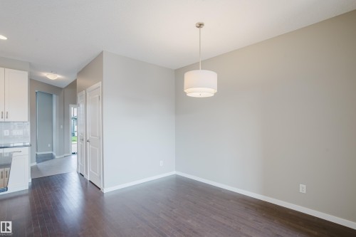 Spacious room featuring rich wood-finish flooring, light grey wall paint, and white baseboards - 17707 59 Street Nw, Edmonton, AB - Indoor