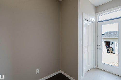 Entryway featuring a white paneled door, a glass-paneled exterior door with transom window, and tile flooring - 17707 59 Street Nw, Edmonton, AB - Indoor Photo Showing Other Room