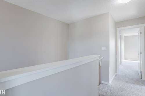 Upper hallway featuring light grey walls and light grey carpet flooring - 17707 59 Street Nw, Edmonton, AB - Indoor Photo Showing Other Room