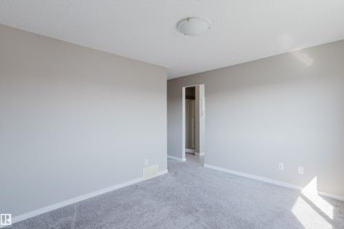 Spacious room featuring neutral paint, gray carpeting, white baseboards, and a flush-mount ceiling light - 17707 59 Street Nw, Edmonton, AB - Indoor Photo Showing Other Room