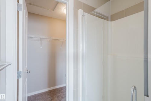 Walk-in shower with clear glass enclosure and light-toned tile surround - 17707 59 Street Nw, Edmonton, AB - Indoor