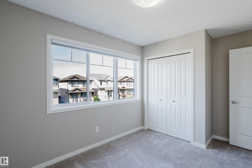 Room featuring a multi-pane window, neutral-toned walls, and a bi-fold closet - 17707 59 Street Nw, Edmonton, AB - Indoor