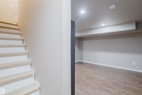 Open concept living space featuring wood-finish flooring, recessed lighting, and a neutral color palette - 17707 59 Street Nw, Edmonton, AB - Indoor Photo Showing Other Room