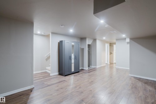 Spacious room featuring wood-finish flooring, recessed lighting, and light-toned wall paint - 17707 59 Street Nw, Edmonton, AB - Indoor