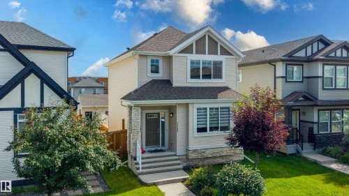 Two-story residence featuring light-colored siding with stone accents on the front facade - 17707 59 Street Nw, Edmonton, AB - Outdoor With Facade
