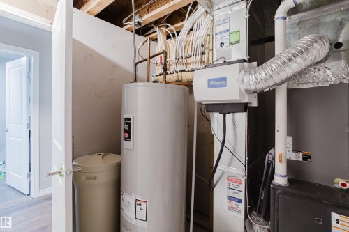 Utility area featuring a water heater, water softener, forced air furnace, and humidifier - 17707 59 Street Nw, Edmonton, AB - Indoor Photo Showing Basement