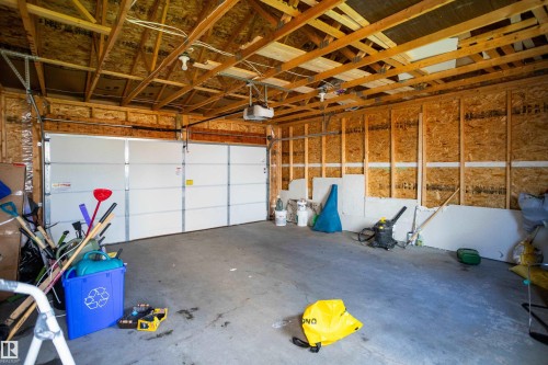 Two-car garage with overhead door and exposed wood framing - 17707 59 Street Nw, Edmonton, AB - Indoor Photo Showing Garage