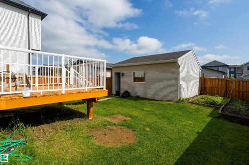 Outdoor deck with a white railing system, featuring wooden floorboards and structural supports - 17707 59 Street Nw, Edmonton, AB - Outdoor With Deck Patio Veranda
