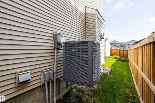 Exterior featuring tan horizontal siding, a central air conditioning unit, and a utility meter - 17707 59 Street Nw, Edmonton, AB - Outdoor