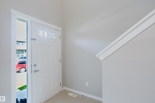 Entryway featuring a paneled door with transom windows, a sidelight, and light gray wall paint - 17707 59 Street Nw, Edmonton, AB - Indoor Photo Showing Other Room