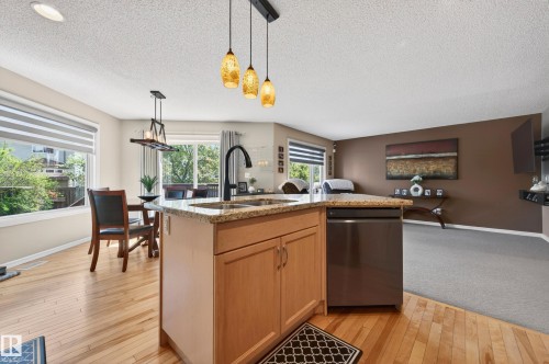 Kitchen island featuring a stainless steel dishwasher, an undermount sink with a matte black faucet, and a granite countertop - 9 Snowbird Crescent, Leduc, AB - Indoor Photo Showing Kitchen With Double Sink