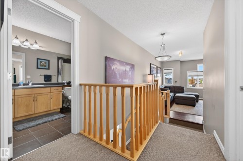 Upper-level hallway featuring a wood balustrade, neutral carpet, and recessed lighting - 9 Snowbird Crescent, Leduc, AB - Indoor Photo Showing Other Room