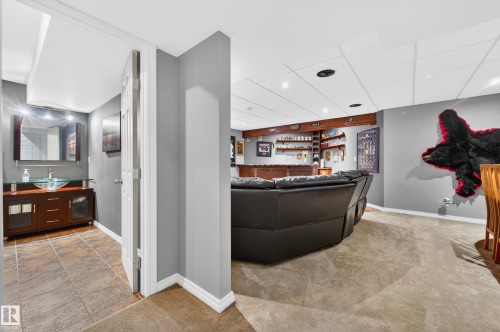 Recreational area featuring a built-in wet bar with wood shelving, integrated lighting, and a drop ceiling - 9 Snowbird Crescent, Leduc, AB - Indoor Photo Showing Other Room