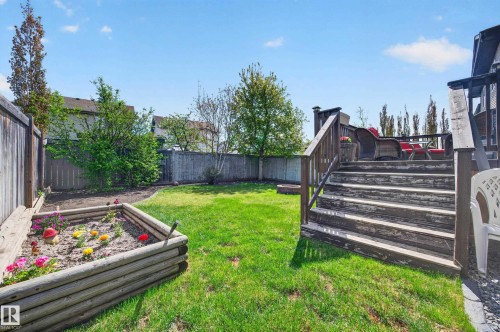 Spacious backyard featuring a wooden deck with railing, a raised garden bed, and a full privacy fence - 9 Snowbird Crescent, Leduc, AB - Outdoor