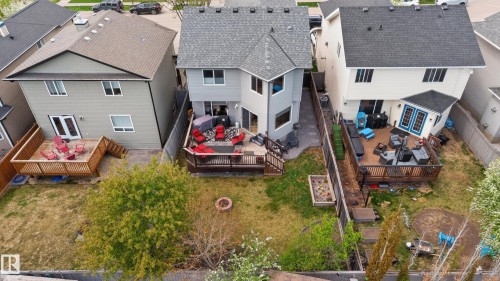 Rear exterior featuring a multi-level wooden deck, stone patio, and a fire pit area - 9 Snowbird Crescent, Leduc, AB - Outdoor
