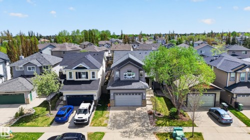 Traditional exterior with light-colored siding, dark shingle roof, and an integrated two-car garage - 9 Snowbird Crescent, Leduc, AB - Outdoor With Facade
