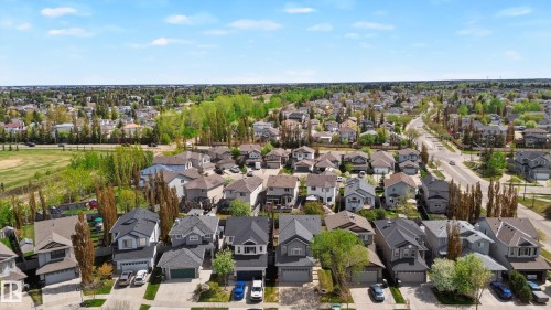 Aerial perspective showcasing a residential neighborhood with a mix of single-family homes, mature trees, and paved roads - 9 Snowbird Crescent, Leduc, AB - Outdoor With View