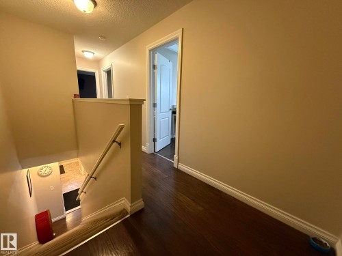 Hallway with wood-finish flooring, white baseboards, and neutral wall paint - #93 12050 17 Av Sw, Edmonton, AB - Indoor Photo Showing Other Room