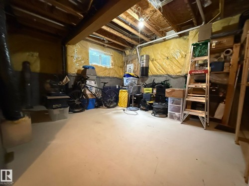 Unfinished basement area featuring a window, exposed ceiling joists, concrete block foundation walls, a concrete floor, and exposed ductwork - #93 12050 17 Av Sw, Edmonton, AB - Indoor Photo Showing Basement