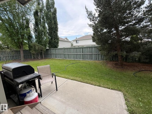 Expansive backyard featuring a concrete patio, a green lawn, and a perimeter fence - #93 12050 17 Av Sw, Edmonton, AB - Outdoor With Backyard