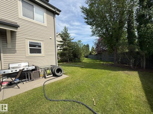 Expansive grassy yard featuring mature trees and a privacy fence - #93 12050 17 Av Sw, Edmonton, AB - Outdoor