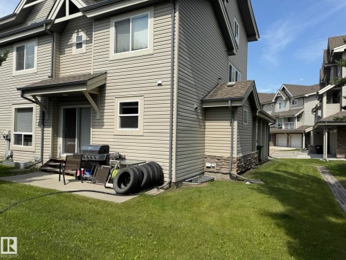 Rear exterior featuring a concrete patio, sliding glass door access, and a small awning - #93 12050 17 Av Sw, Edmonton, AB - Outdoor With Deck Patio Veranda