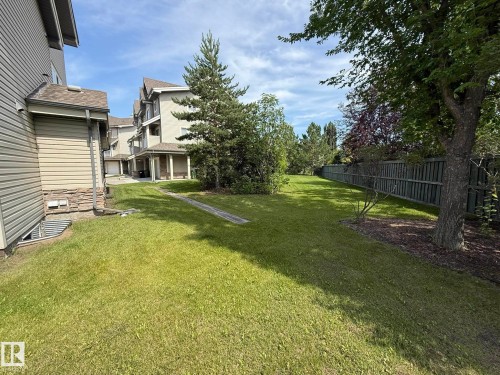Expansive green lawn with mature trees and a privacy fence - #93 12050 17 Av Sw, Edmonton, AB - Outdoor