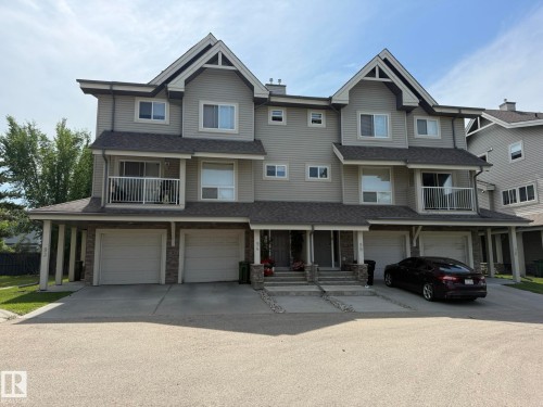 Townhome exterior featuring light gray siding, dark trim, and multiple gabled rooflines - #93 12050 17 Av Sw, Edmonton, AB - Outdoor With Facade