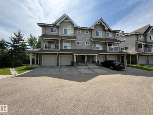 Multi-level townhouse exterior featuring light gray siding and dark gray shingled roofs - #93 12050 17 Av Sw, Edmonton, AB - Outdoor With Facade
