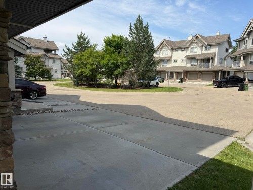Stone pillar detailing with a concrete driveway and an asphalt street - #93 12050 17 Av Sw, Edmonton, AB - Outdoor With Facade