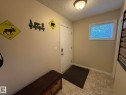 Entryway with ceramic tile flooring, a panel door, an overhead semi-flush mount light fixture, and a window with blinds - #93 12050 17 Av Sw, Edmonton, AB  - Indoor Photo Showing Other Room 