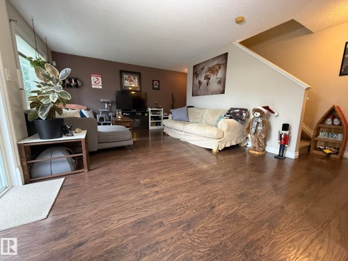Spacious living area featuring rich wood-finish flooring throughout - #93 12050 17 Av Sw, Edmonton, AB - Indoor Photo Showing Living Room