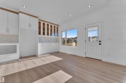 Light wood-finish flooring complements the crisp white walls and recessed ceiling lighting - 