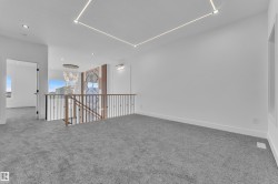 Spacious upper-level landing with plush gray carpeting and recessed ceiling lighting - 