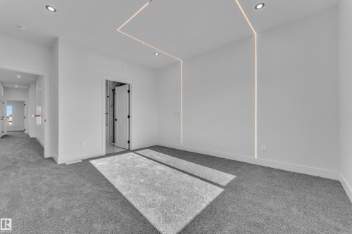 Spacious room featuring gray carpeting, recessed ceiling lighting, and linear wall lighting elements - 382 Linden Loop, Leduc, AB - Indoor Photo Showing Other Room