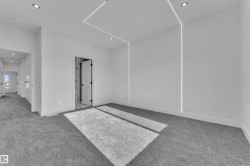 Spacious room featuring gray carpeting, recessed ceiling lighting, and linear wall lighting elements - 