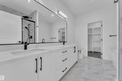 Modern bathroom featuring a dual vanity with integrated sinks, white cabinetry, and matte black hardware - 382 Linden Loop, Leduc, AB - Indoor