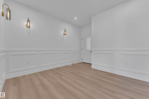 Hardwood-finish flooring complementing white wainscoting - 382 Linden Loop, Leduc, AB - Indoor Photo Showing Other Room