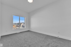 Room featuring a large window, gray carpeting, white walls, white baseboards, and a flush-mount ceiling light fixture - 