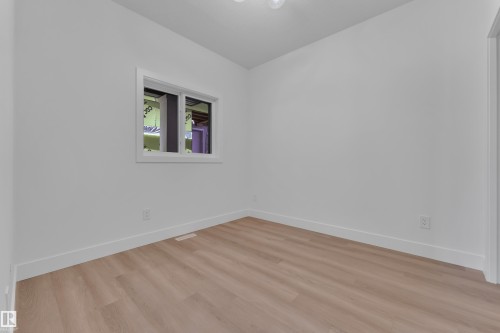 Neutral-toned wood-finish flooring complements white walls and trim throughout this space - 382 Linden Loop, Leduc, AB - Indoor Photo Showing Other Room