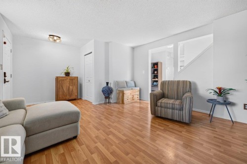 Bright living space featuring wood-finish flooring, white painted walls, and a textured ceiling - 17411 90 Street Nw, Edmonton, AB - Indoor Photo Showing Living Room