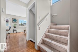 Carpeted staircase with white handrail leading to an upper level - 
