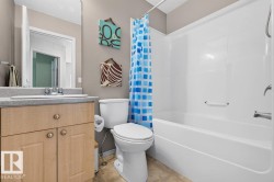 Bathroom featuring a light-finish wood vanity with a light-toned countertop, an integrated sink, and a chrome faucet - 