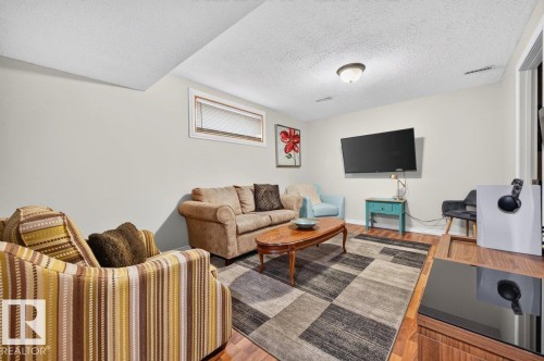 Inviting living area featuring warm neutral wall tones and wood-finish flooring - 17411 90 Street Nw, Edmonton, AB - Indoor Photo Showing Other Room