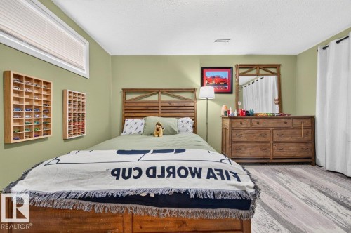 Room featuring wood-finish flooring, a neutral wall color, and a high window with blinds - 17411 90 Street Nw, Edmonton, AB - Indoor Photo Showing Bedroom