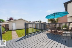 Spacious outdoor deck with painted wood flooring and dark railings - 
